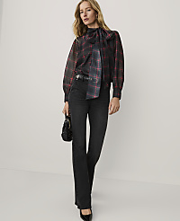 A woman wearing a red and black plaid bow-neck blouse and black jeans stands against a plain white background. carousel Product Image 3