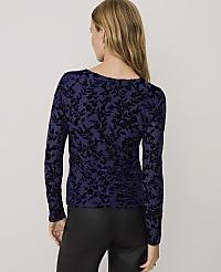 A woman wearing a navy blue floral velvet top and black leather pants stands against a plain light gray background. carousel Product Image 2