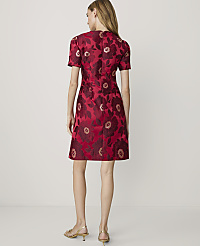 A woman in a red floral dress stands against a plain, light-colored background. carousel Product Image 2