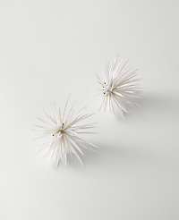 Two white, spiky floral ornaments rest on a plain, light gray background. carousel Product Image 1