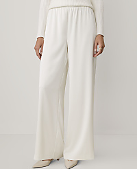 A person wearing a white ribbed sweater and wide-leg white trousers stands against a plain, light-colored background. carousel Product Image 2