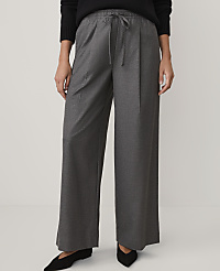 A person wearing a black sweater, wide-leg grey trousers, and black pointed shoes stands against a plain white background. carousel Product Image 3