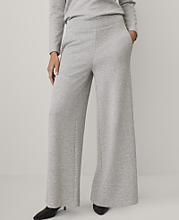 A person wears a light grey long-sleeved top and matching wide-leg trousers with black pointed heels against a plain, light-colored background. carousel Product Image 2