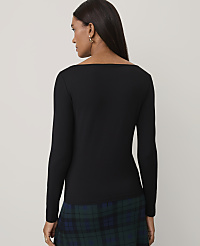 A woman wearing a black long-sleeved top and a green plaid skirt stands against a plain light gray background. carousel Product Image 2