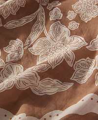 White floral patterns are printed across a textured, rust-brown fabric background. carousel Product Image 2