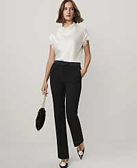 A woman wearing a white lace-trimmed top and black trousers stands against a plain white background. carousel Product Image 3