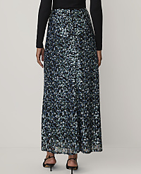 A person wearing a black long-sleeved top and a shimmering blue and silver sequined maxi skirt stands against a plain white background. carousel Product Image 3