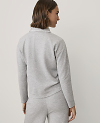 A woman with brown hair wearing a grey matching sweatshirt and pants set stands against a plain white background. carousel Product Image 2