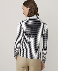 A woman wearing a black and white striped long-sleeved shirt and khaki pants stands against a plain light gray background. carousel Product Image 2