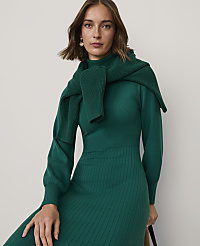 A woman wearing a green ribbed knit dress and a matching sweater draped over her shoulders poses against a plain light gray background. carousel Product Image 3