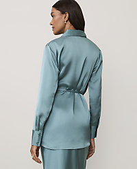 A woman wearing a teal satin shirt and matching trousers stands against a plain, light-colored background. carousel Product Image 2