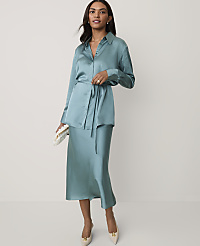 A woman wearing a teal satin shirt and matching midi skirt stands against a plain white background. carousel Product Image 3