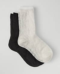 A white sock rests on top of two black socks against a plain light gray background. carousel Product Image 1