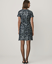 A woman stands with her back to the camera wearing a short, sequined blue and black dress and black heels against a plain white background. carousel Product Image 2