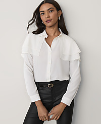 A woman wearing a white ruffled blouse and black leather pants stands against a plain light-grey background. carousel Product Image 1