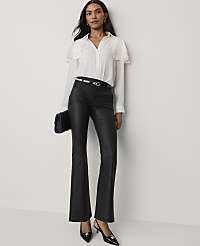 A woman wearing a white ruffled blouse and black faux-leather trousers stands against a plain white wall. carousel Product Image 3