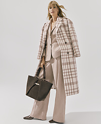 A woman wearing a plaid coat and matching suit holds a dark brown handbag against a plain white background. carousel Product Image 4