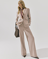 A blonde woman wearing a mauve power suit and a patterned scarf stands against a plain white background. carousel Product Image 4