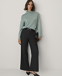 A woman wearing a light green sweater and dark wide-leg trousers stands against a plain white background. carousel Product Image 3