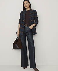 A woman wearing a plaid blazer, dark top, and wide-leg faux leather trousers stands against a plain, light-colored background. carousel Product Image 1