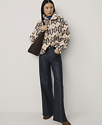 A woman wearing a patterned fuzzy jacket and wide-leg leather trousers stands against a plain, light-colored background. carousel Product Image 4