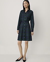 A woman wearing a dark green plaid shirt dress and black heels stands against a plain, light-colored background. carousel Product Image 1
