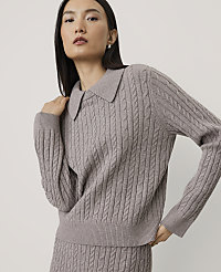 A woman wearing a mauve cable-knit sweater and matching skirt poses against a plain, light-colored background. carousel Product Image 1