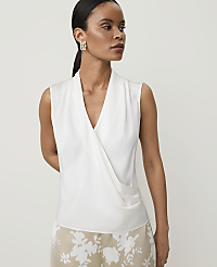 A woman in a white wrap top and floral skirt stands against a plain background. carousel Product Image 1