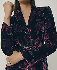 A person wearing a dark blue and purple floral velvet blazer and rings stands against a plain, light-colored background. carousel Product Image 6