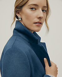 A woman wearing a blue wool coat and silver earrings poses against a plain, light-colored background. carousel Product Image 2