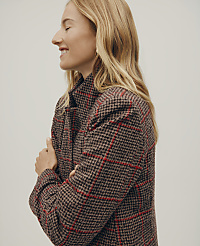 A smiling blonde woman in a brown and red plaid coat stands against a plain, light-colored background. carousel Product Image 4