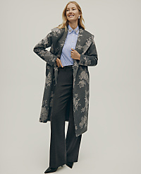 A smiling woman wearing a floral grey coat, a blue striped shirt, and wide-leg trousers stands against a plain light grey background. carousel Product Image 4