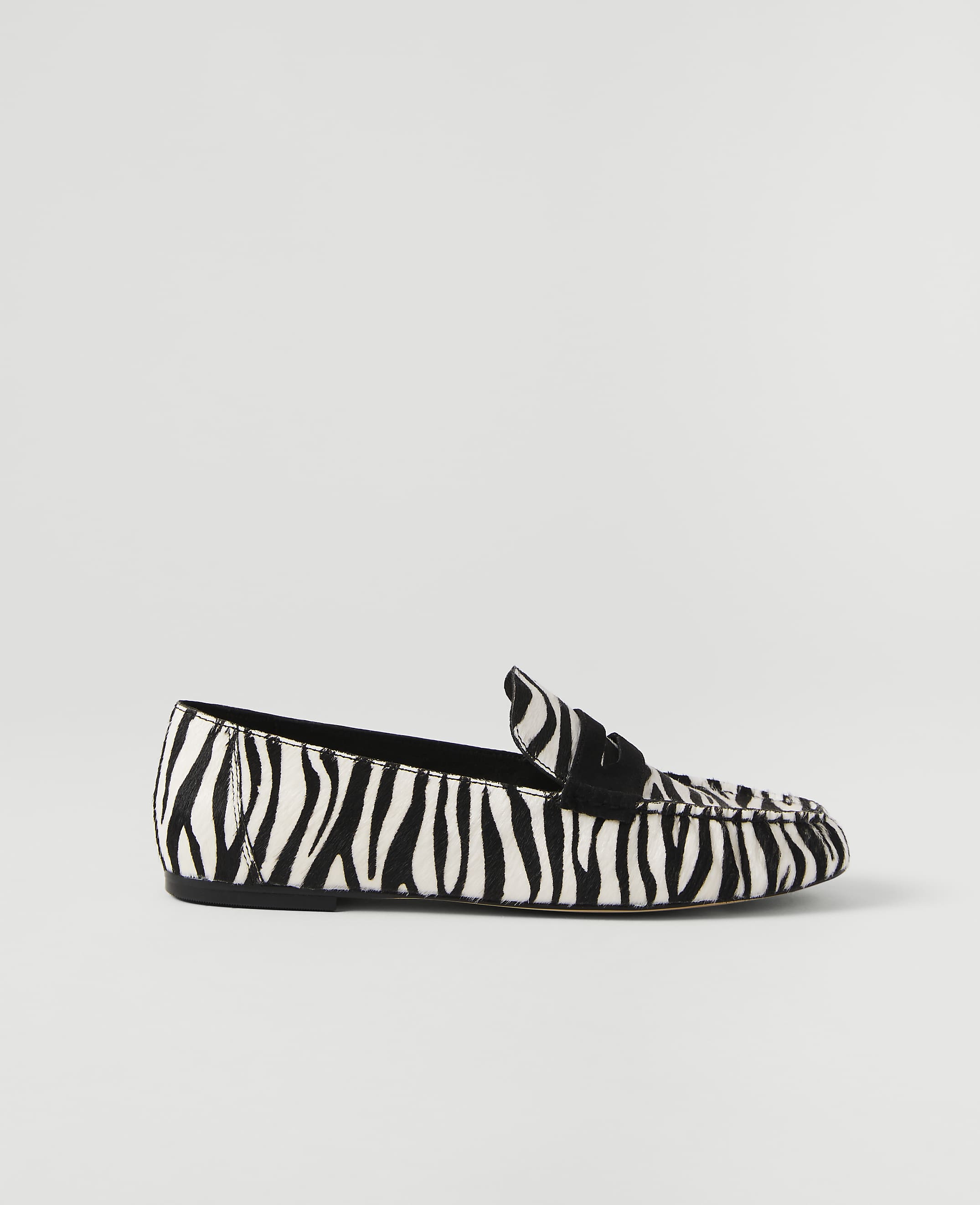 A zebra-print loafer rests on a plain white background.