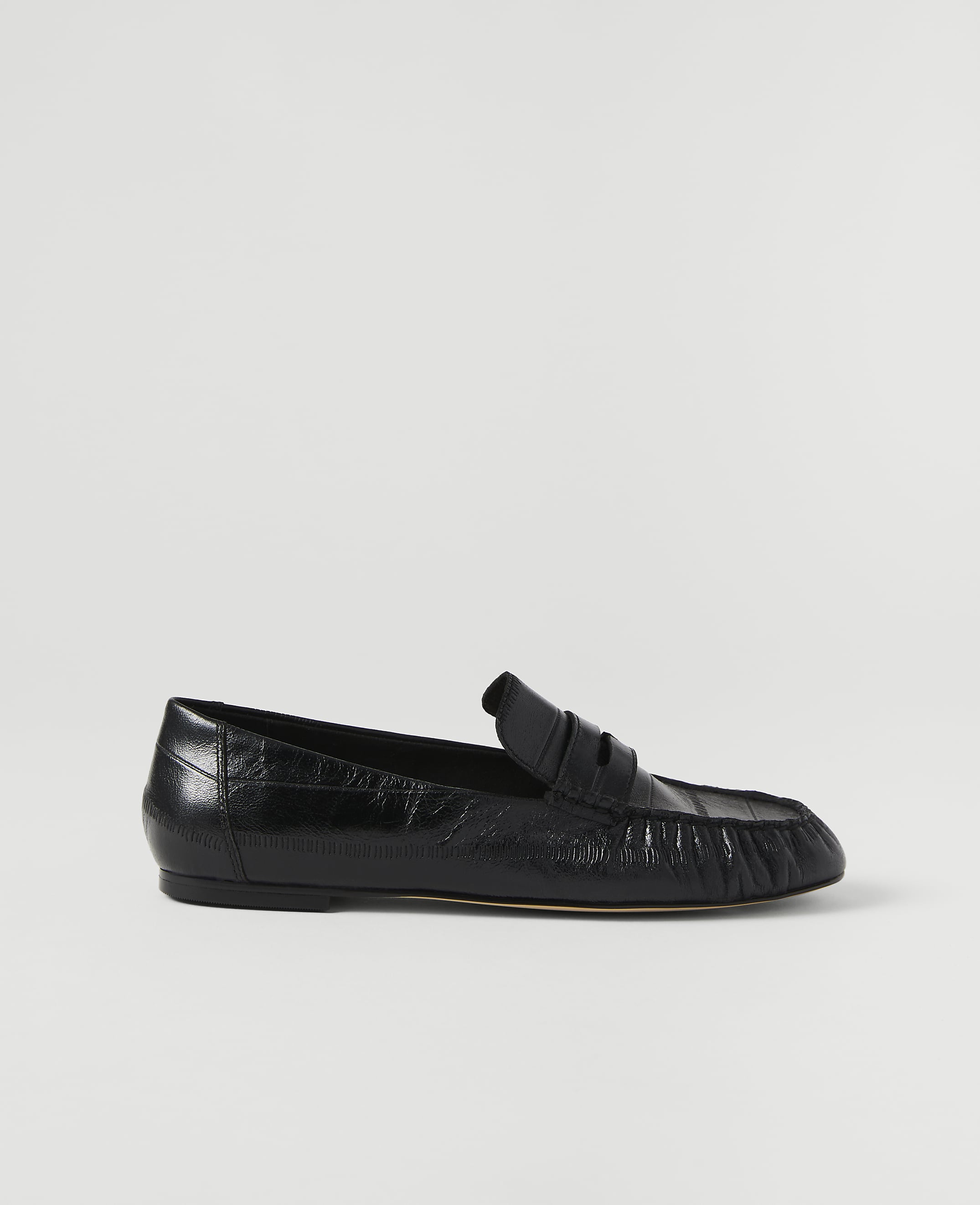 A black leather loafer rests on a plain white background.