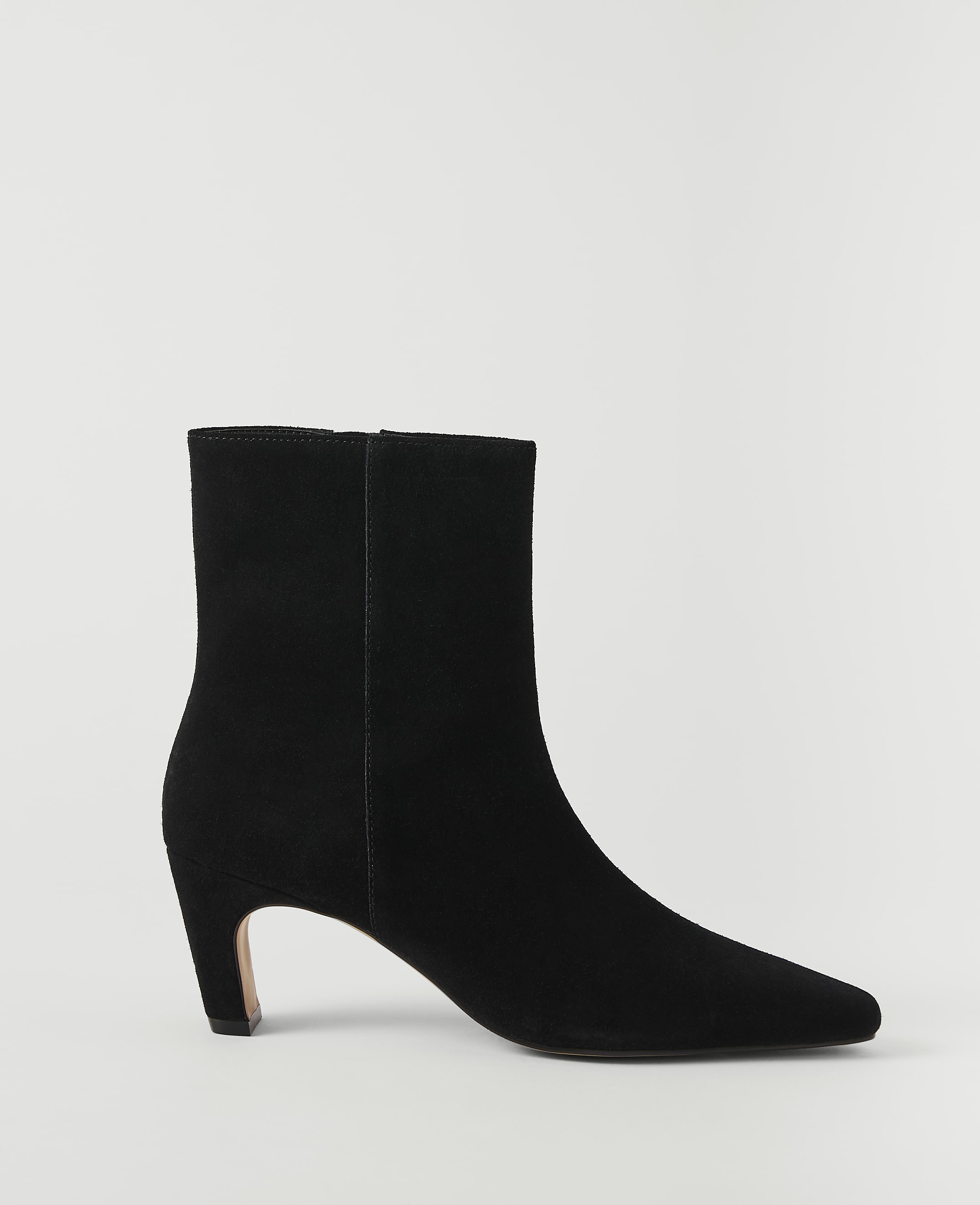 A black suede ankle boot with a pointed toe and a low heel stands against a plain white background.