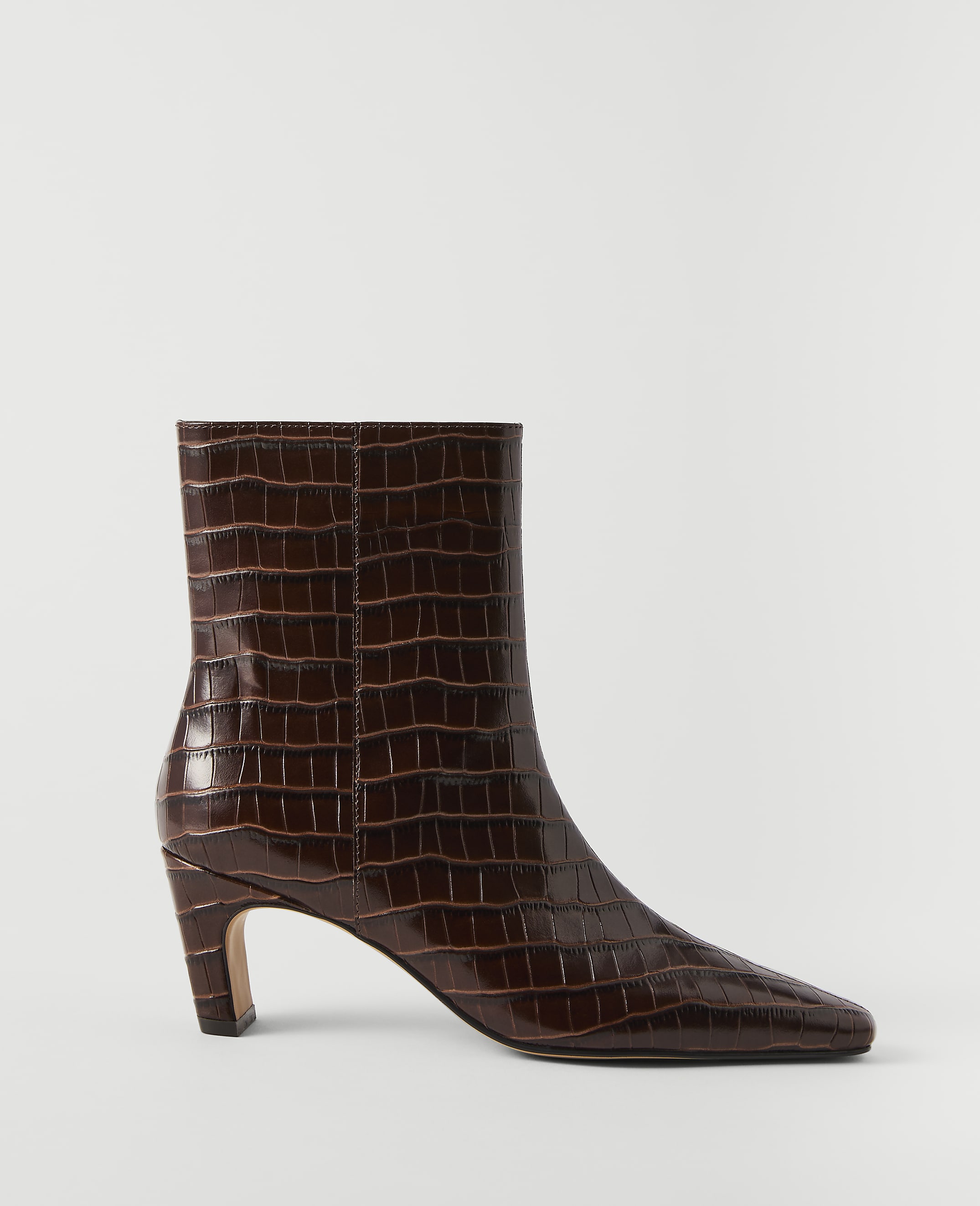 A glossy brown crocodile-embossed ankle boot with a pointed toe and a flared heel stands against a plain white background.