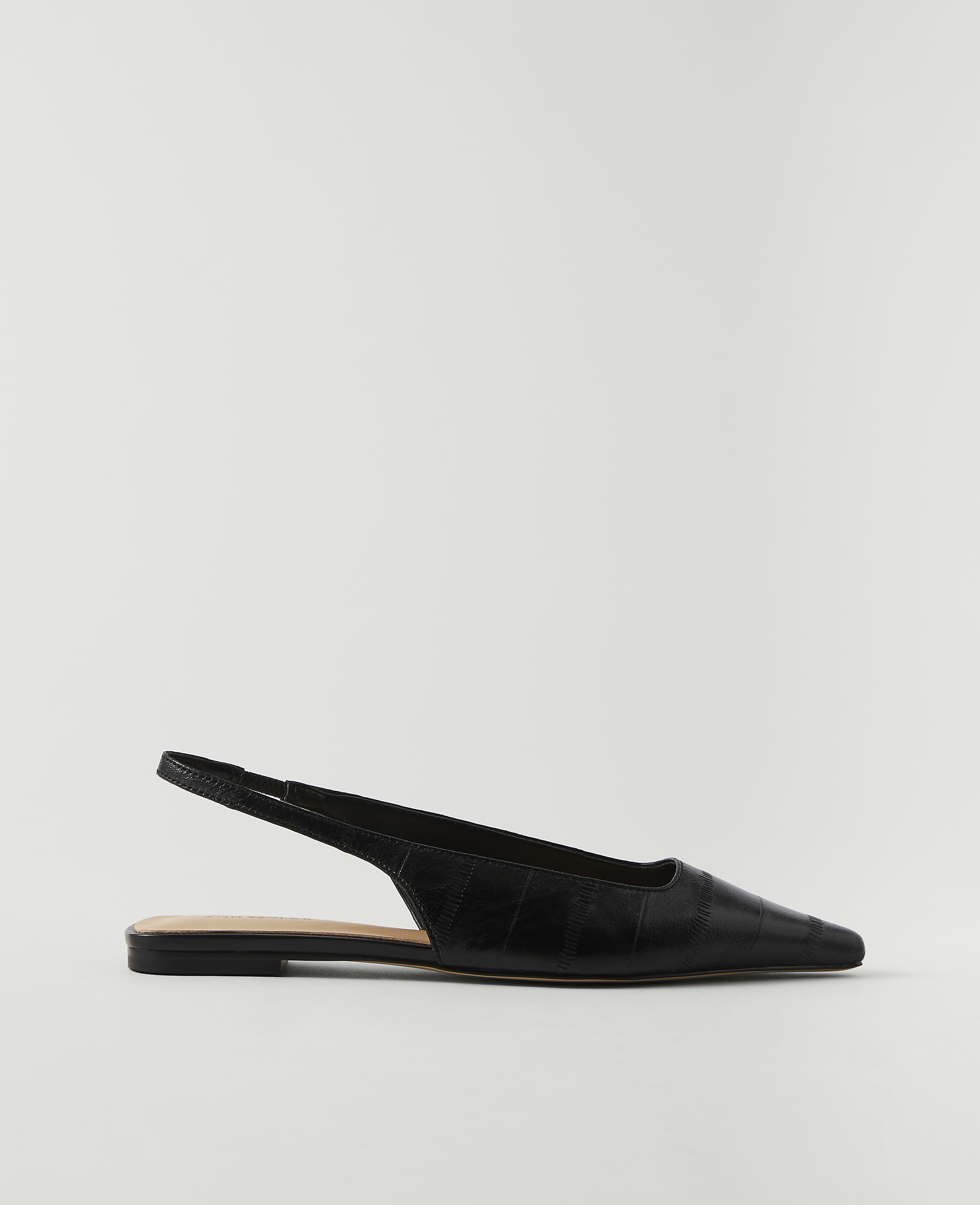 A black, pointed-toe slingback flat with a crocodile-embossed texture rests on a plain white background.
