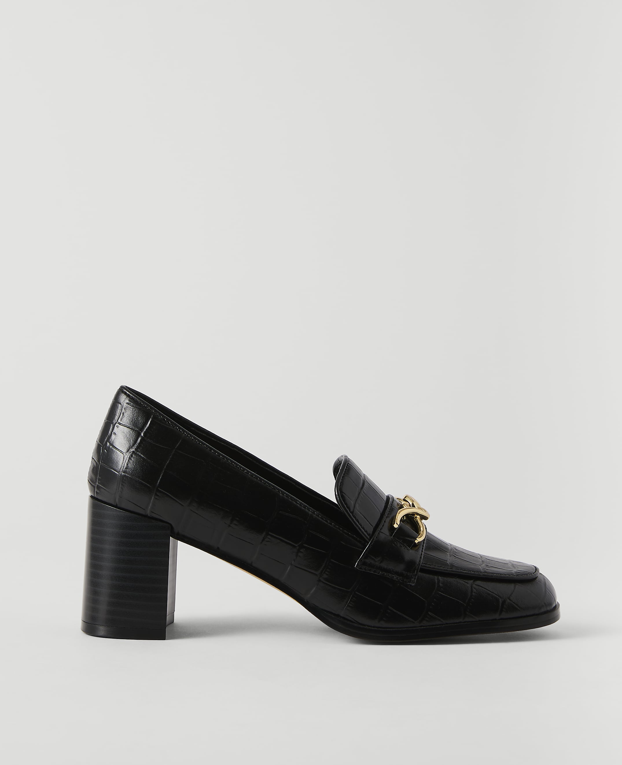 A black, croc-embossed loafer with a gold buckle sits on a plain white background.
