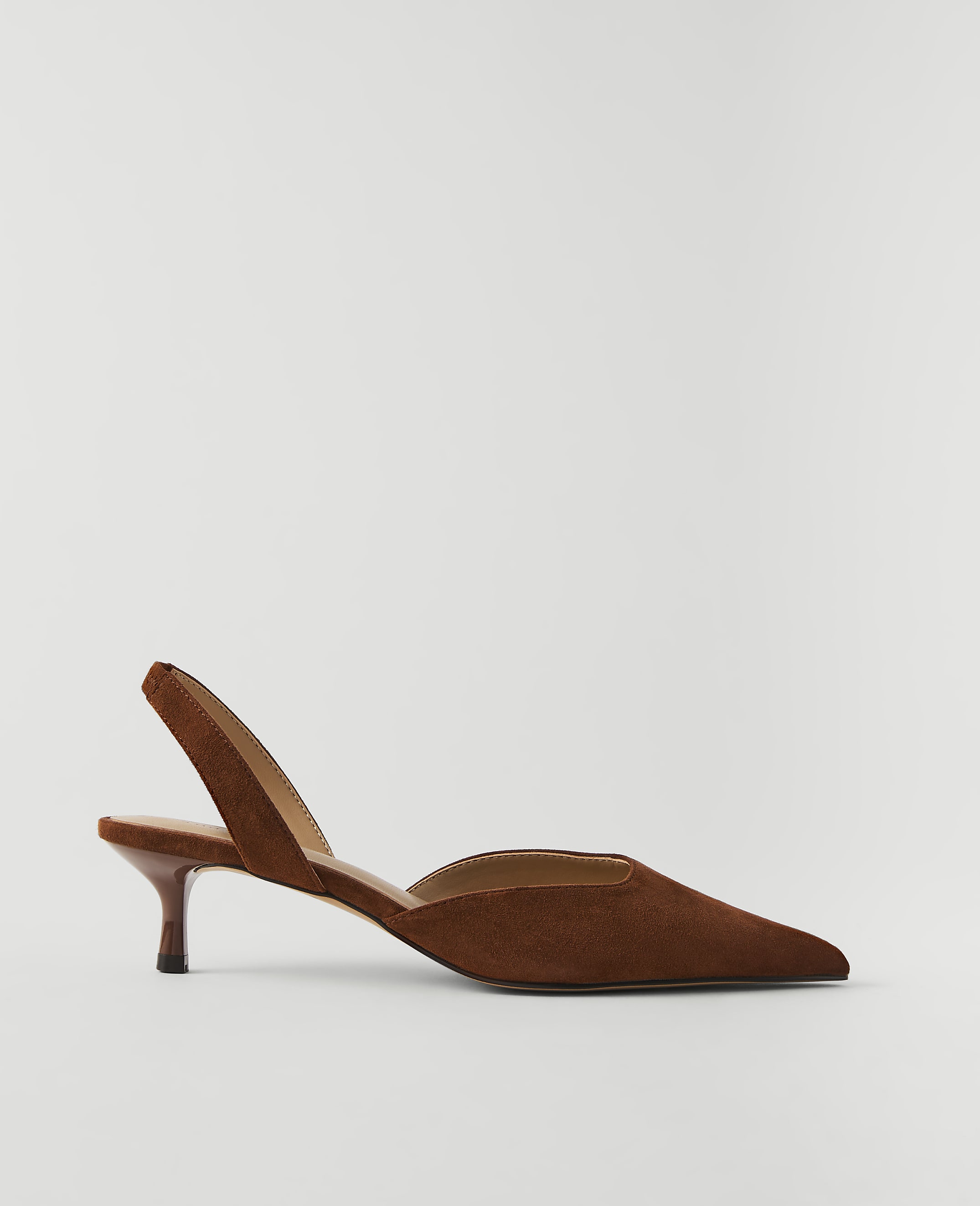 A brown suede slingback heel with a pointed toe rests on a plain white background.