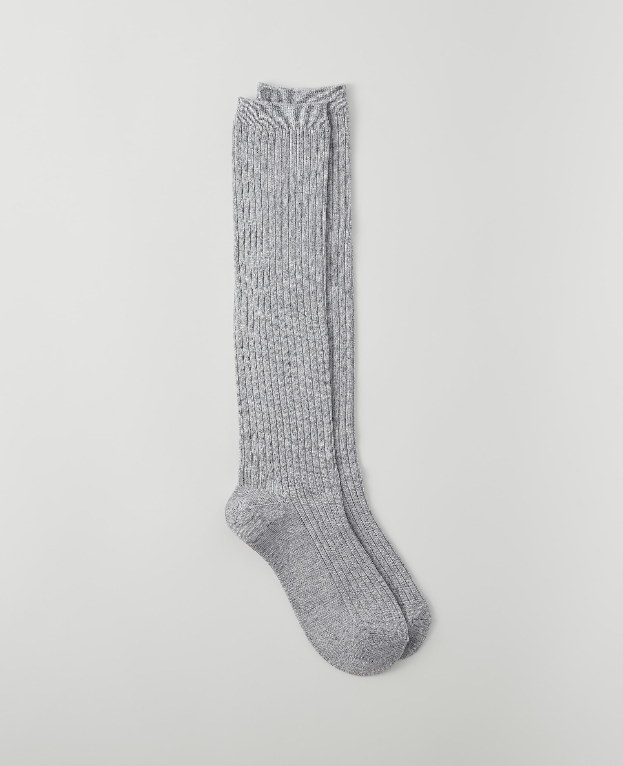 A pair of ribbed grey knee-high socks lies on a plain light grey background.