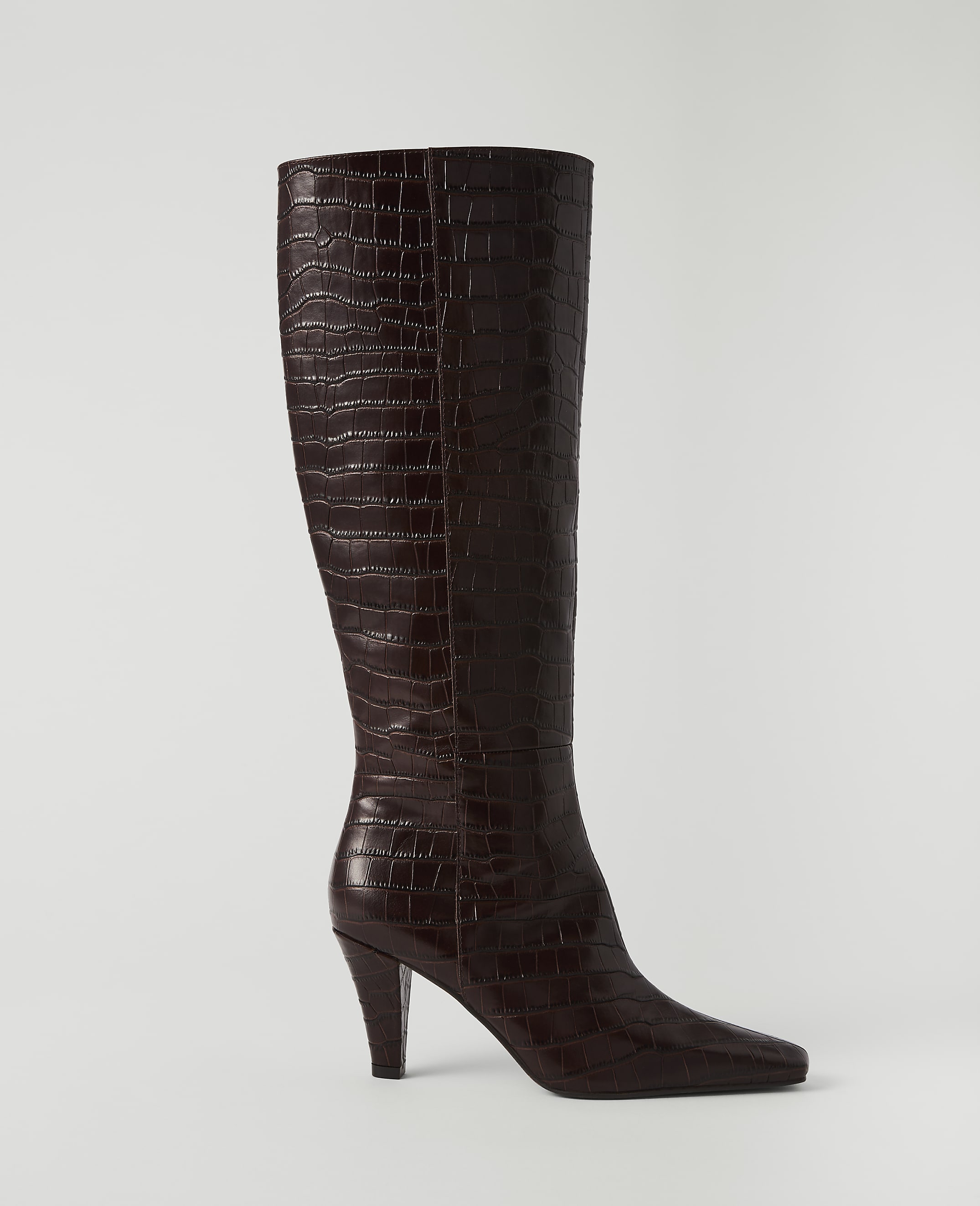 A dark brown, croc-embossed leather knee-high boot with a pointed toe and stiletto heel stands against a plain white background.