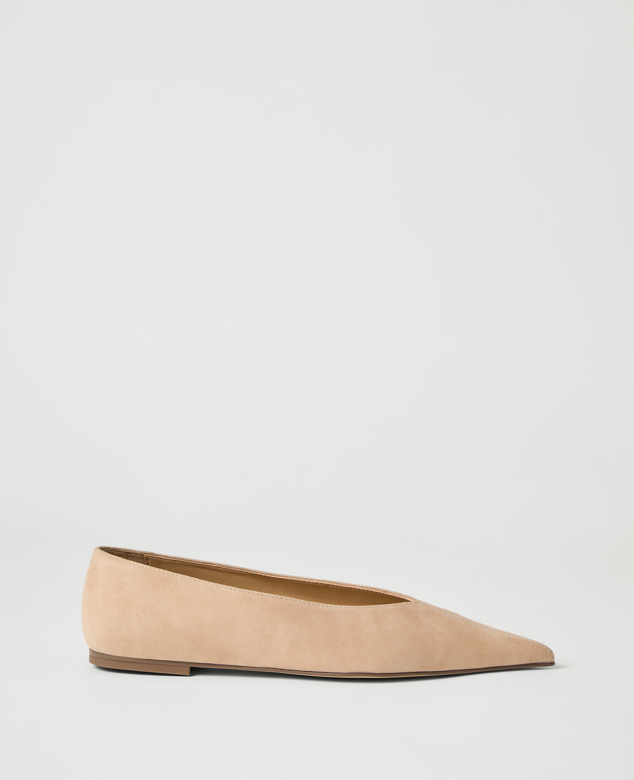 A pale pink pointed-toe flat shoe rests on a plain white background.