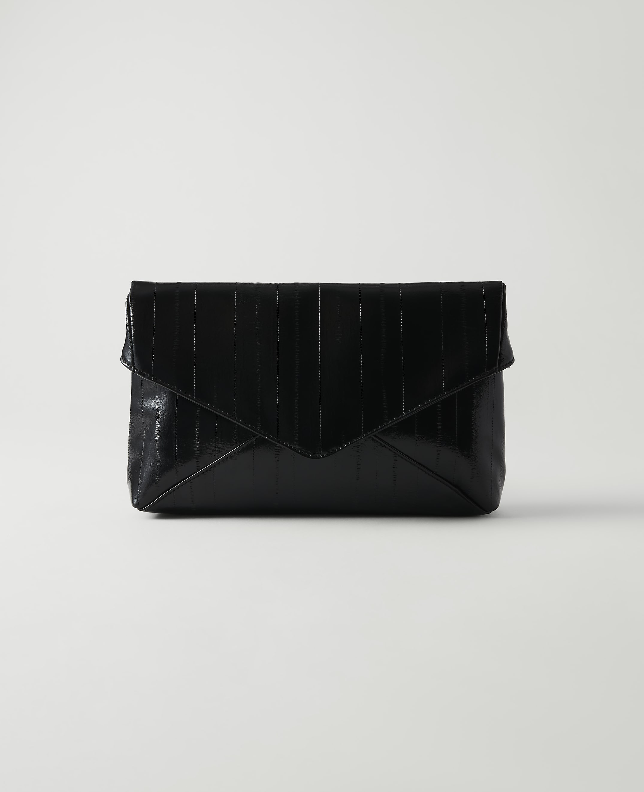 A black, textured envelope clutch rests on a white surface against a plain white background.