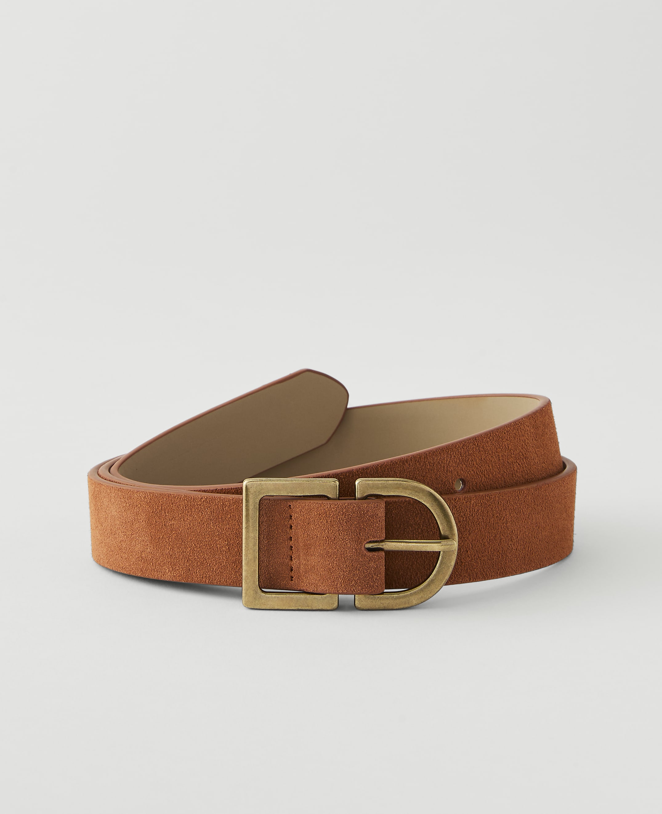 A rust-colored suede belt with a brass buckle lies on a plain, light gray background.