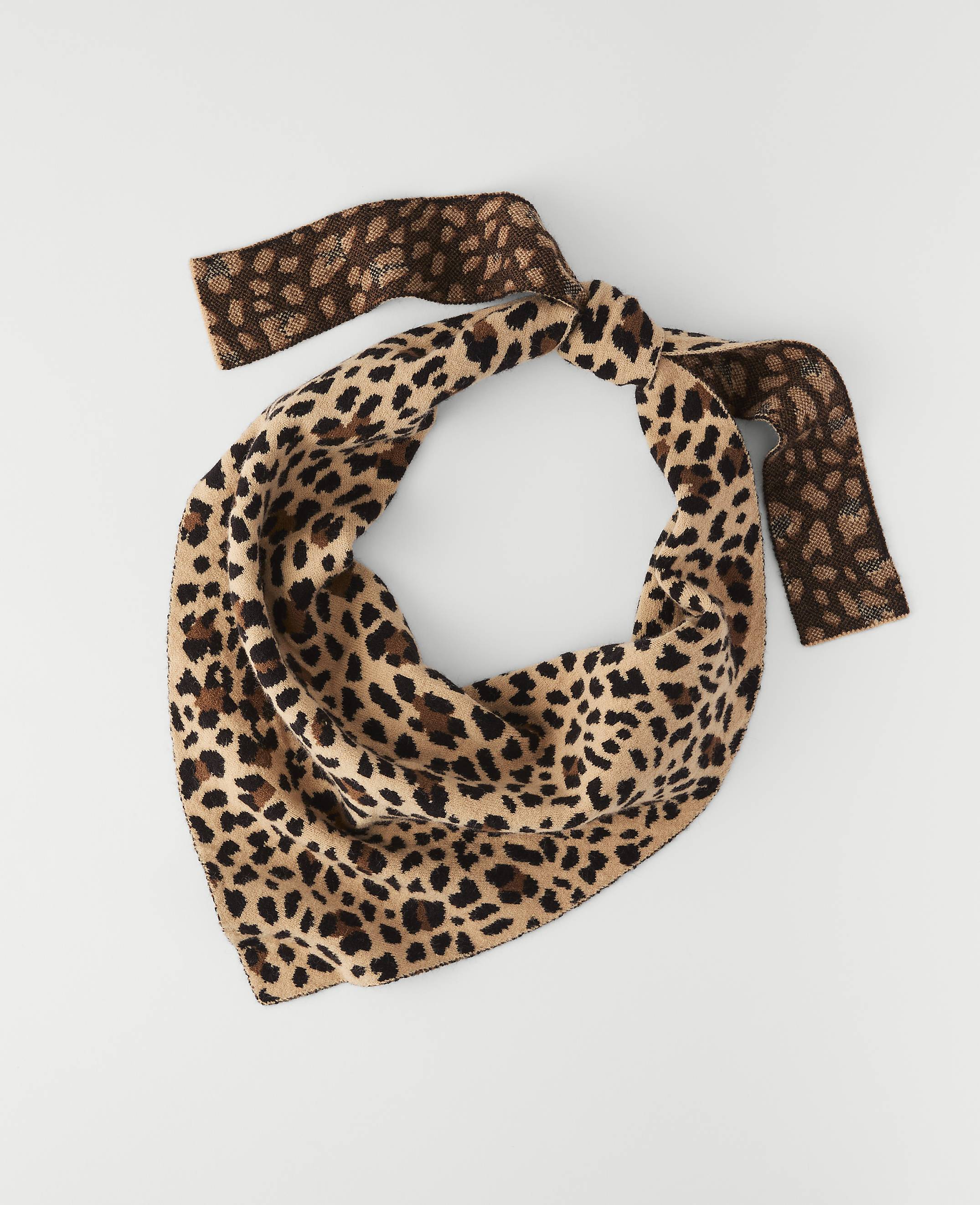 A leopard-print bandana with brown accents is laid flat against a plain white background.