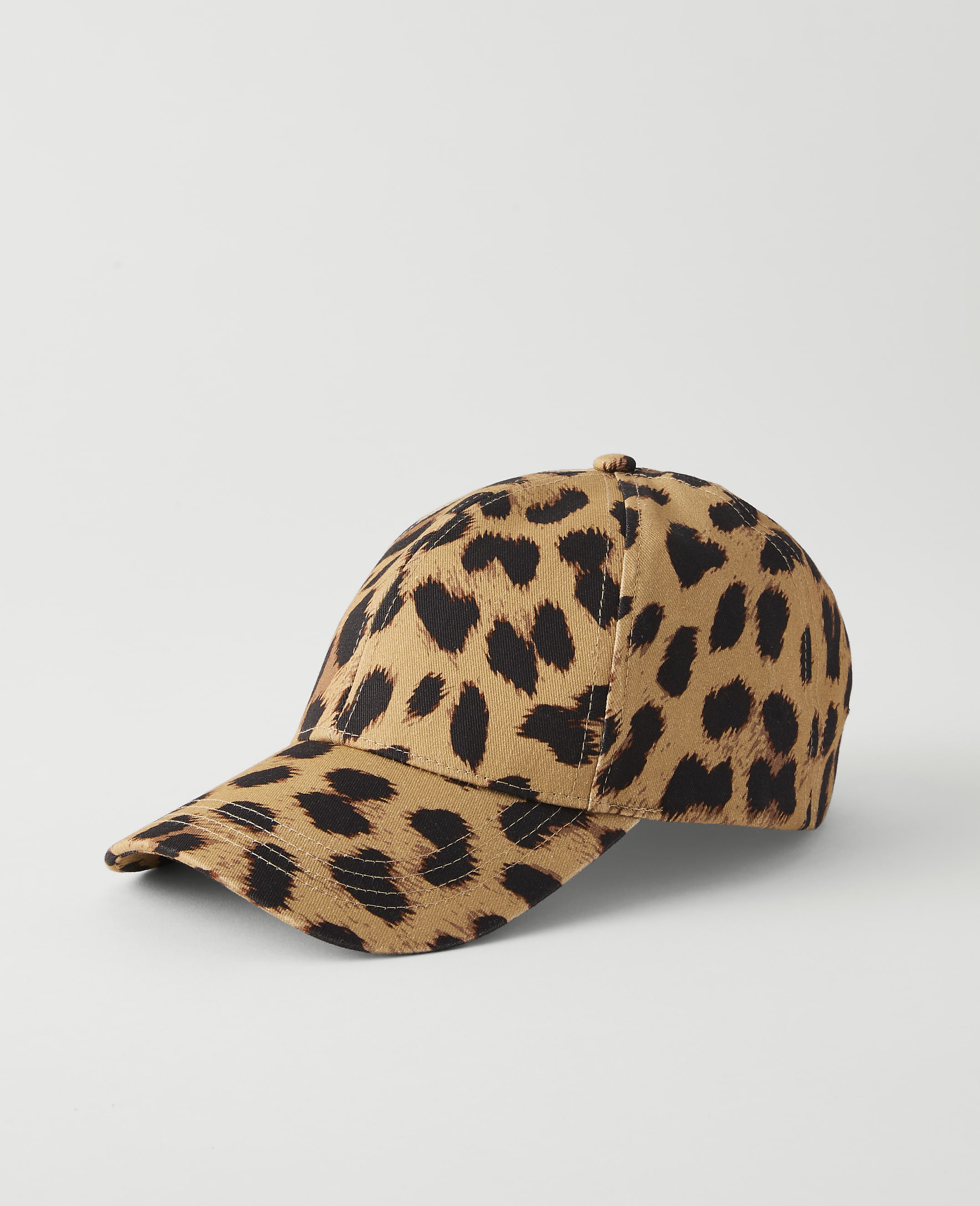 A leopard-print baseball cap rests on a plain white surface against a light gray background.