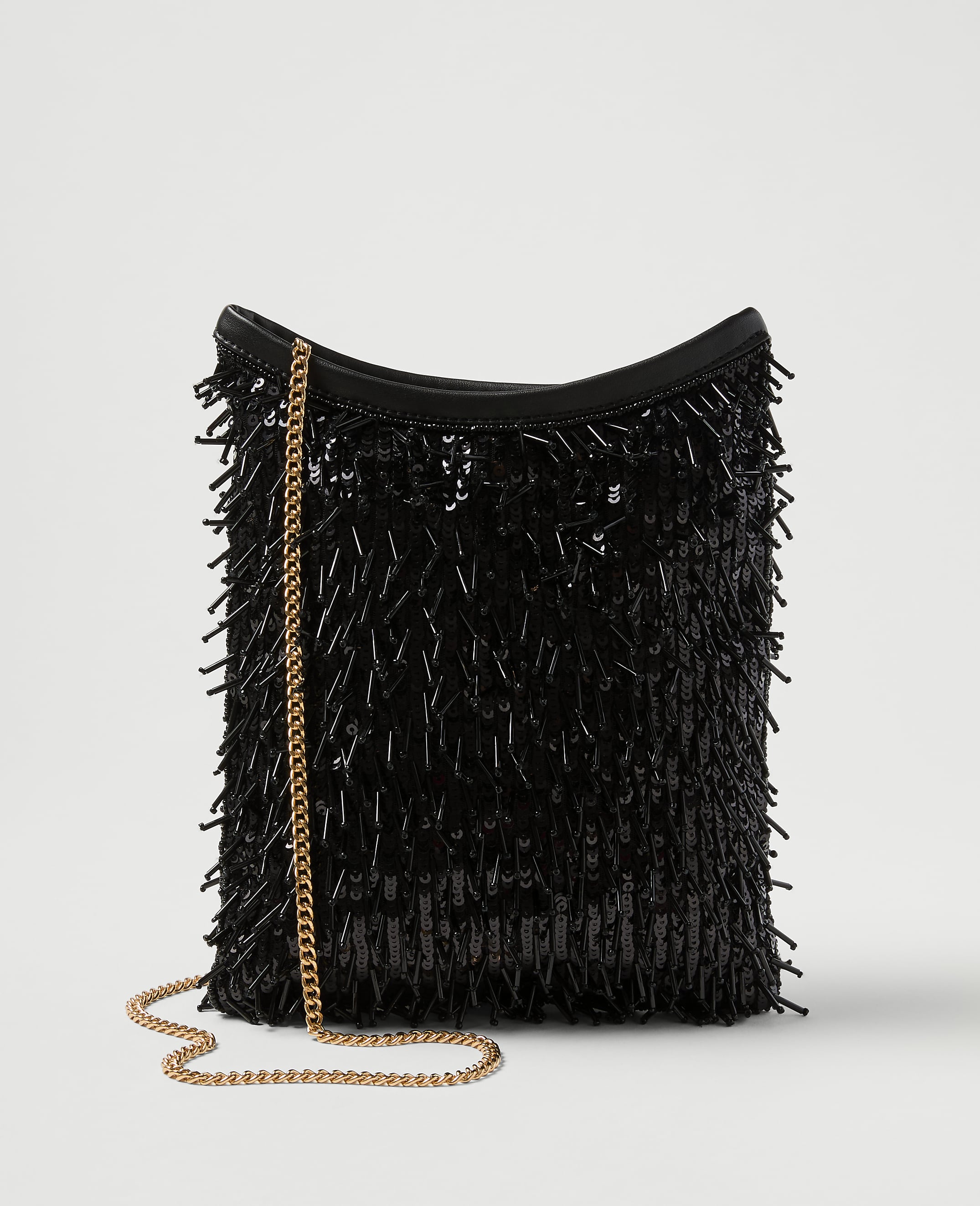 A black sequined fringe bag with a gold chain strap rests against a plain white background.