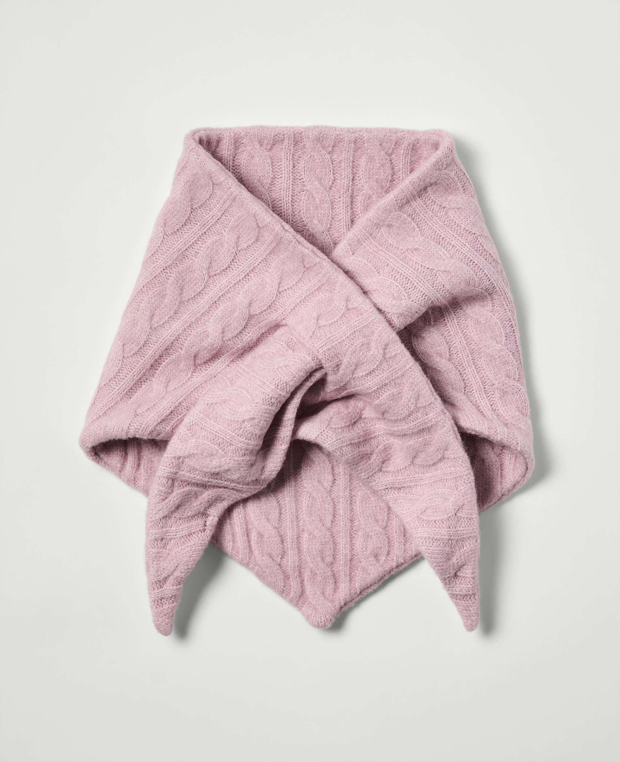 A pink cable-knit scarf is folded into a triangular shape against a plain white background.
