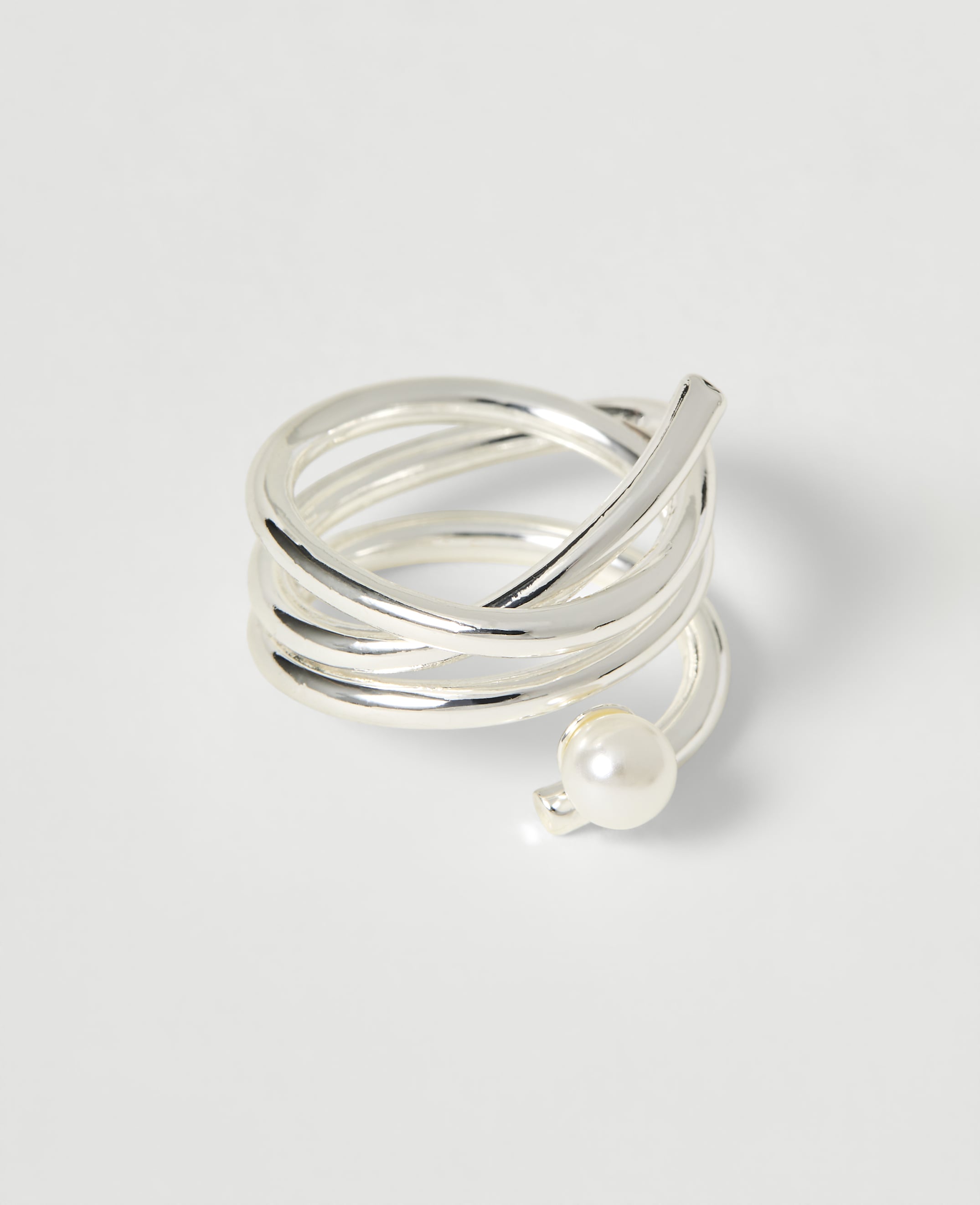 A silver coiled ring with a pearl accent rests on a plain white background.