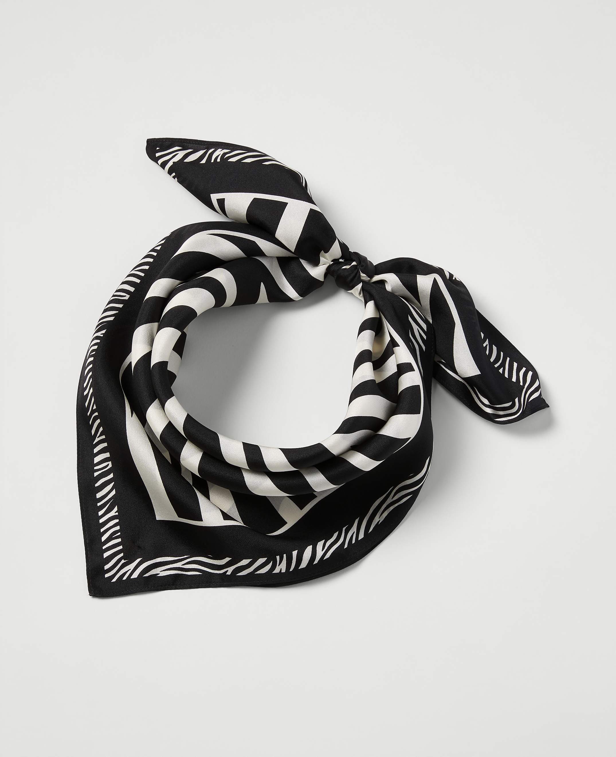 A black and white striped bandana is tied in a knot in the foreground, set against a plain white background.
